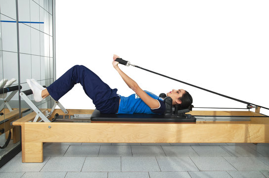 young girl performs exercises with pilates gear