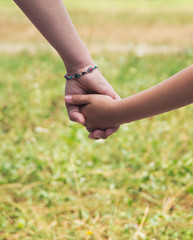 Mother holding a hand of her son