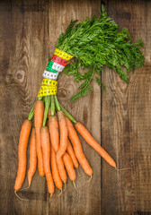 fresh carrots with measurement tape. diet and healthy eating con