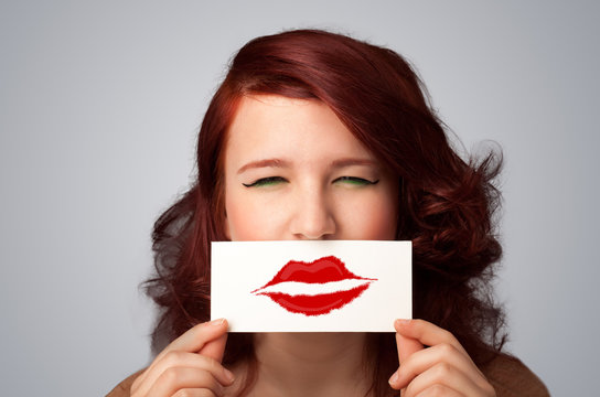 Happy pretty woman holding card with kiss lipstick mark