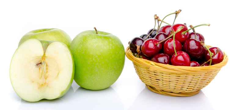 Green apples and a basket of cherries