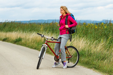 Happy woman on a bike in nature