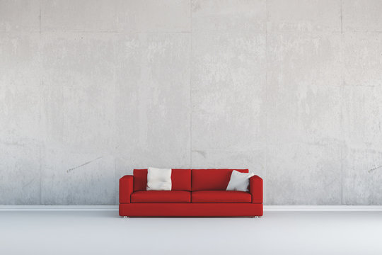 Rotes Sofa vor Wand aus Beton