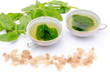 Composition with two cups of mint tea, fresh mint and brown cane