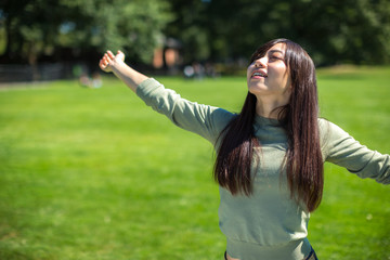 Young Asian Woman feeling happy refreshed in a park