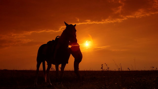 Horseback riding to the horizon at sunset