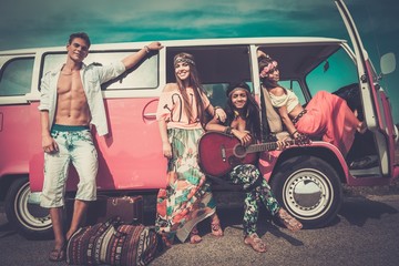 Multi-ethnic hippie friends with guitar on a road trip