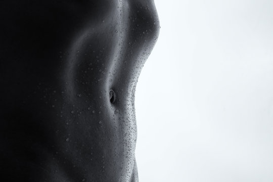 Bodyscape of a nude woman with wet stomach and back lighting art