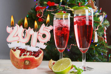 Two glasses with red champagne and candles 2015