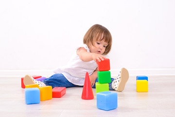 little girl playing with colored cubes