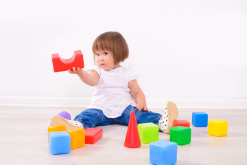 Fototapeta na wymiar little girl playing with colored cubes