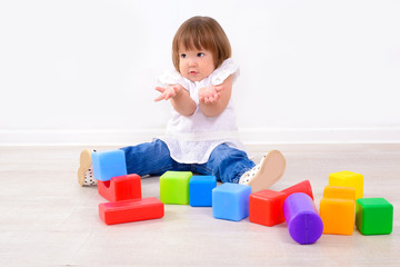 Fototapeta na wymiar little girl playing with colorful cubes