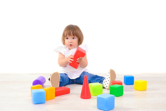 little girl playing with colored cubes