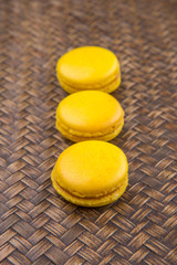 Obraz na płótnie Canvas Yellow colored French macarons on wicker background