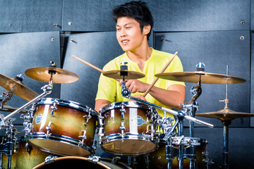 Fototapeta na wymiar Asian musician drummer in recording studio