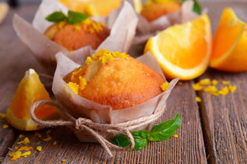 Tasty cupcakes with orange on table close-up