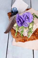 Old letters and flowers on wooden background close-up