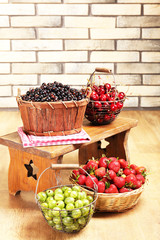 Fresh berries in basket on wall background