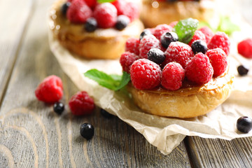 Sweet cakes with berries on table close-up