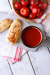 Homemade tomato juice in color mug, bread sticks, spices and