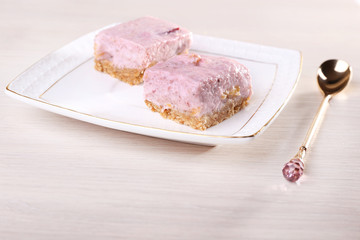 Cakes on plate with spoon on wooden background