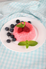 Round shaped cake with berries on plate on napkin