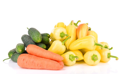 Yellow peppers with cucumbers and carrots isolated on white
