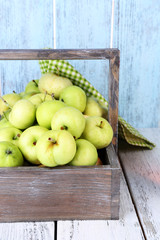 Ripe apples in box on wooden table close-up