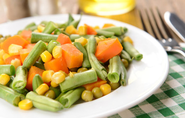 Delicious vegetables salad on plate on table close-up