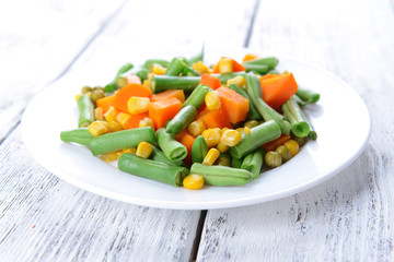 Delicious vegetables salad on plate on table close-up