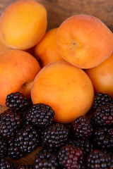 Apricots and blackberries on table close up