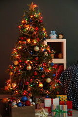 Decorated Christmas tree on home interior background at night