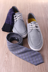 Top-Siders, pair of socks and tie on wooden background