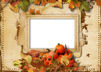 Pumpkins, autumn leaves and frame for photo on vintage backgroun