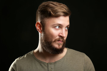 Portrait of handsome man with beard on black background