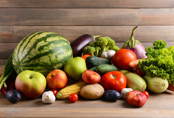 Fresh organic fruits and vegetables on wooden background