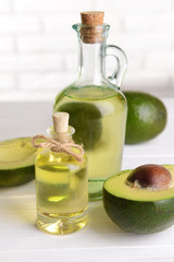 Avocado oil on table on light background