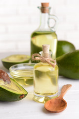 Avocado oil on table on light background