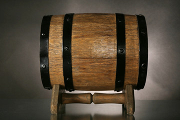 Barrel on wooden table on dark background