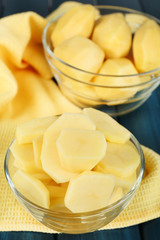 Raw peeled and sliced potatoes in glass bowls