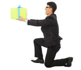 young Business man holding a gift box and kneel.