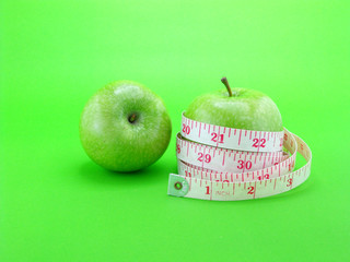 measuring tape wrapped around a green apple for diet