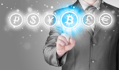 Choosing bitcoins, businessman pressing touch screen button.