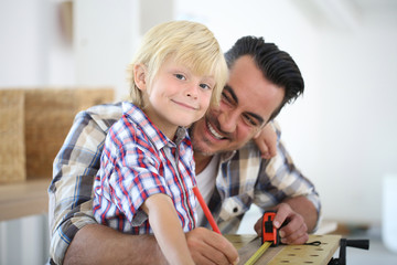 Father with kid measuring wood plank © goodluz