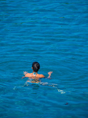 Beautiful girl swimming in blue water