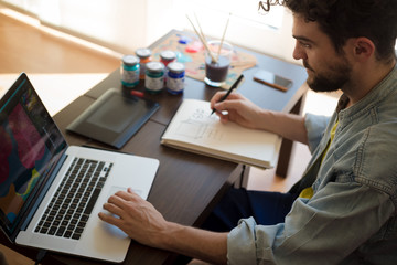 handsome hipster modern man working home using laptop