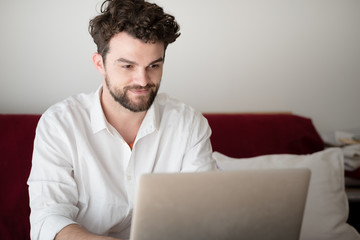 handsome hipster modern man working home using laptop