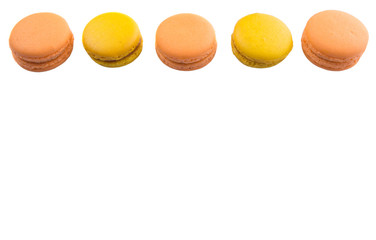 Yellow and orange colored French macarons on white background