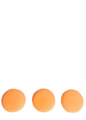Orange colored French macarons over white background