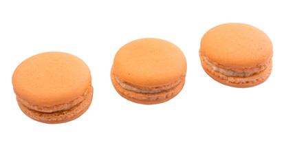 Orange colored French macarons over white background